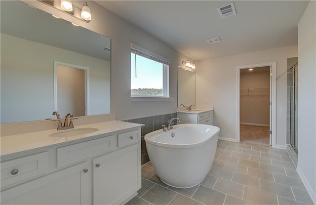 bathroom with tile patterned flooring, vanity, and separate shower and tub