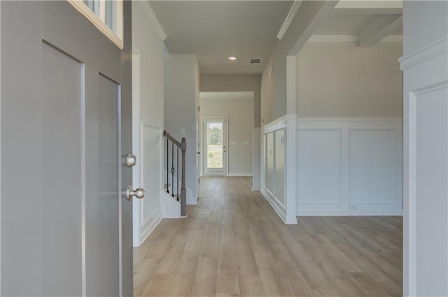 corridor featuring ornamental molding and light hardwood / wood-style flooring