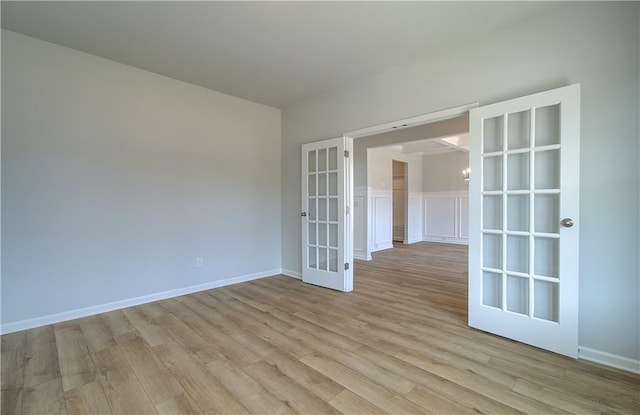 unfurnished room featuring french doors and light hardwood / wood-style flooring