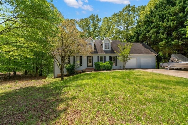 cape cod home featuring an attached garage, concrete driveway, and a front lawn