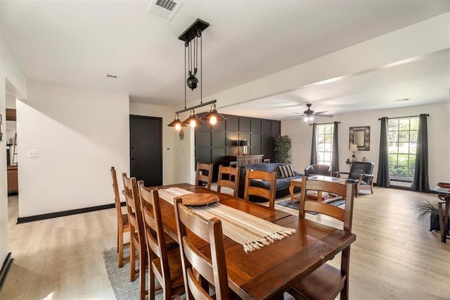 dining room featuring light wood-style floors, ceiling fan, and baseboards