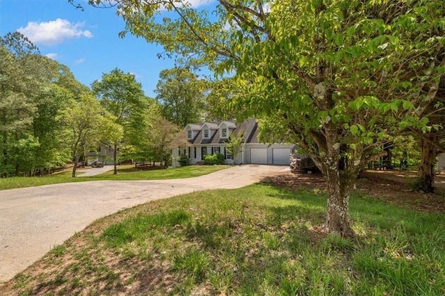 view of front of property featuring a garage, concrete driveway, and a front lawn