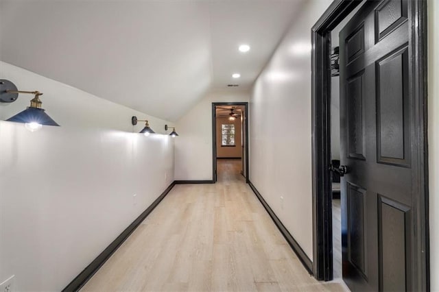 hallway featuring light wood-style floors, baseboards, vaulted ceiling, and recessed lighting