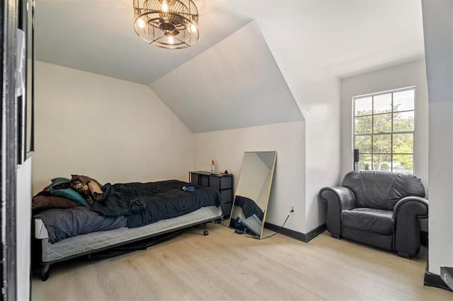 bedroom featuring wood finished floors, vaulted ceiling, and baseboards