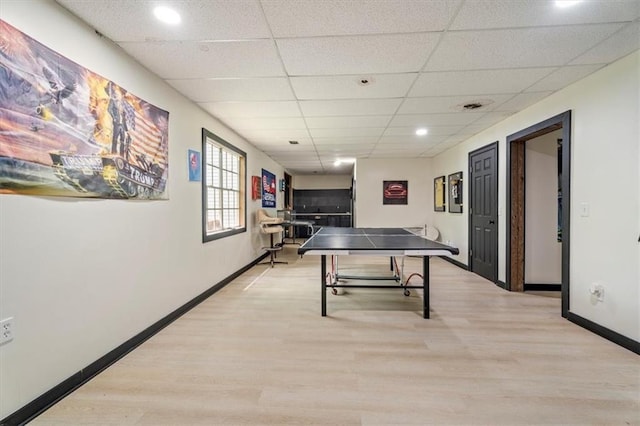 game room featuring light wood-type flooring, baseboards, and a drop ceiling
