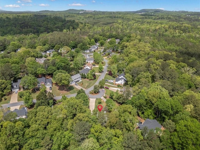 aerial overview of property's location with a heavily wooded area and nearby suburban area