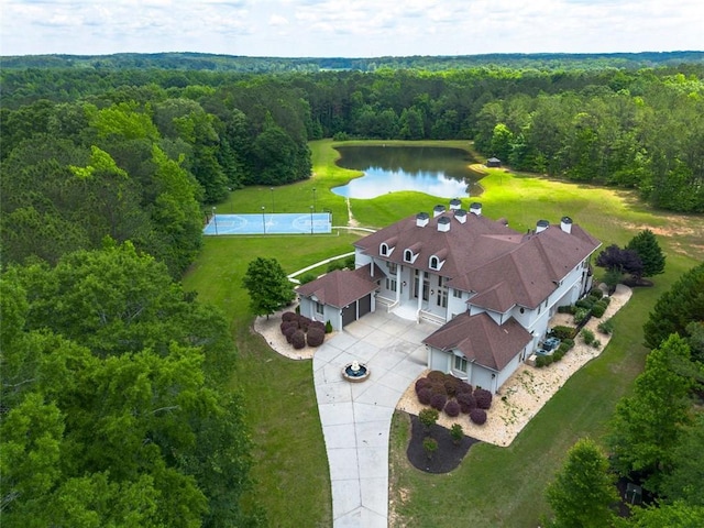 drone / aerial view with a water view and a forest view