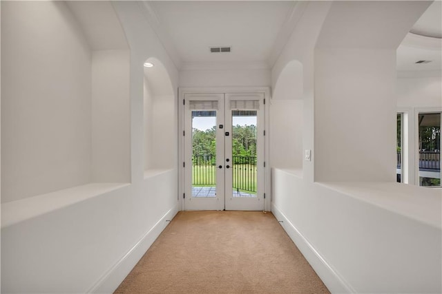 doorway to outside with french doors, crown molding, light colored carpet, visible vents, and baseboards