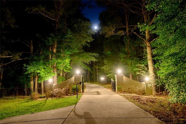 view of community with a fenced front yard and concrete driveway