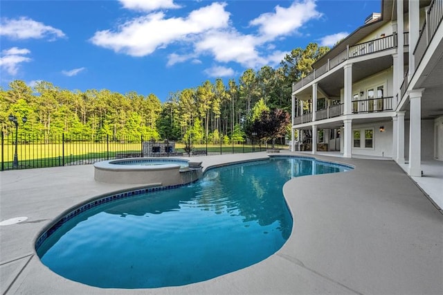 view of swimming pool featuring a patio area, fence, and a pool with connected hot tub