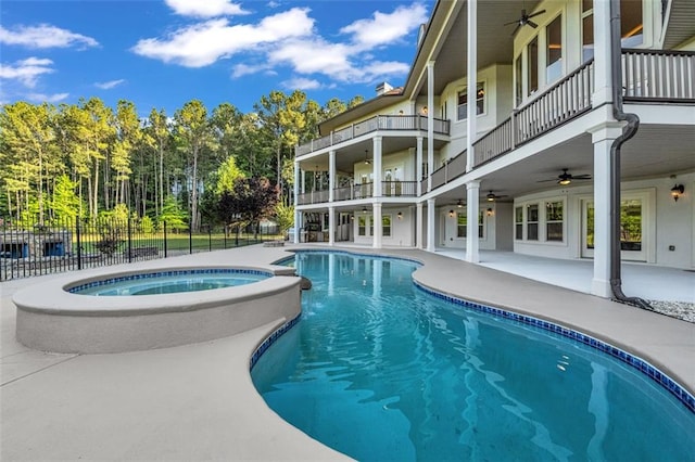 view of pool featuring a pool with connected hot tub, a patio area, ceiling fan, and fence