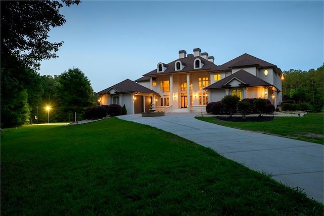 view of front facade featuring a lawn and concrete driveway