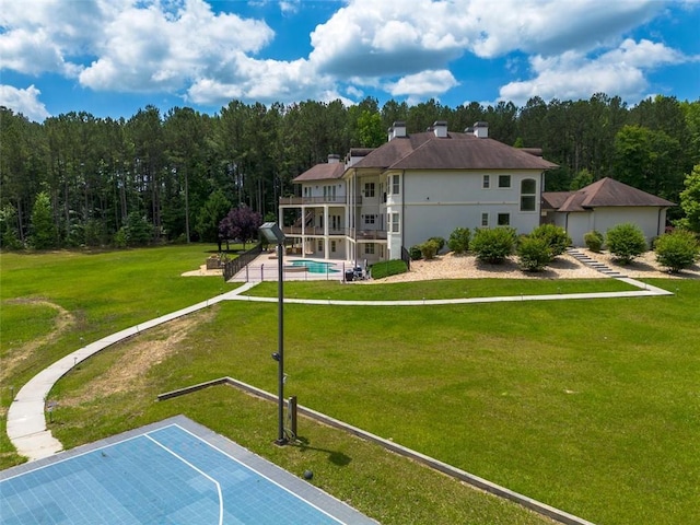 view of basketball court with community basketball court, a lawn, and an outdoor pool