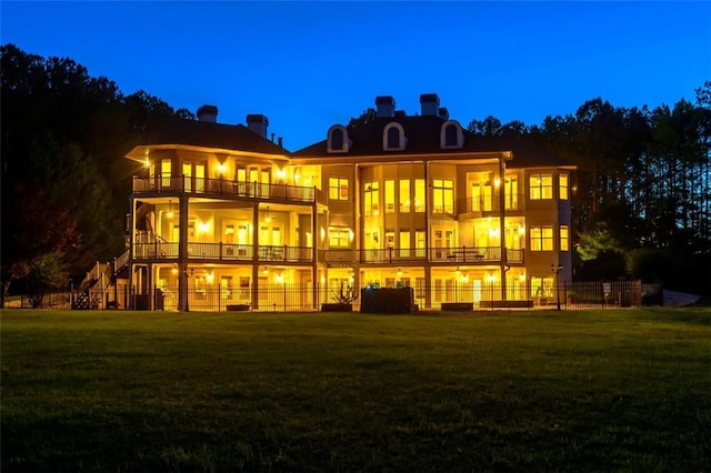 rear view of property with a balcony and a yard