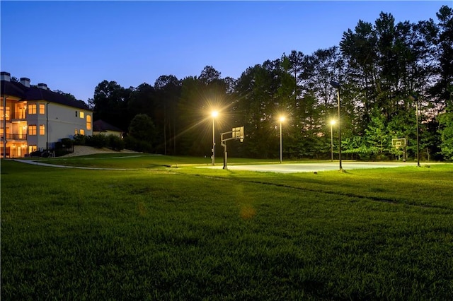 view of property's community with community basketball court and a yard