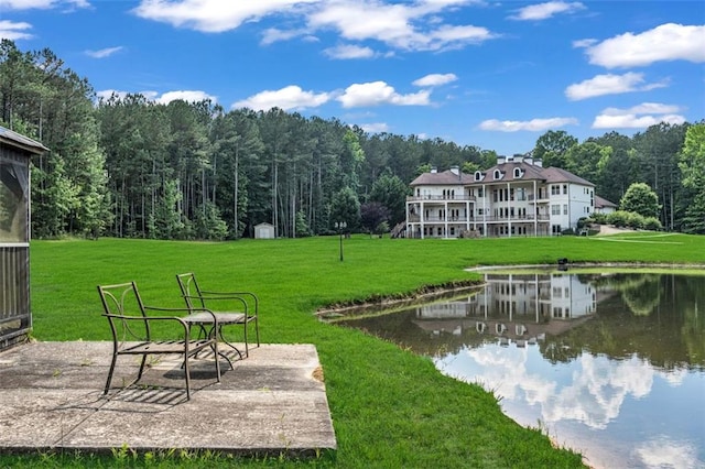 view of home's community with a water view, a patio area, and a yard