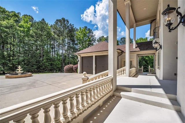 view of patio / terrace featuring an attached garage and concrete driveway