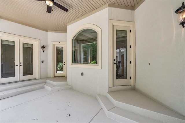 view of exterior entry featuring ceiling fan, french doors, a patio, and stucco siding