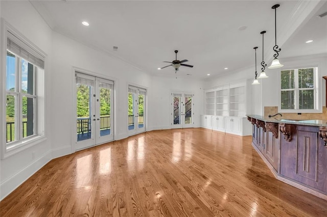 unfurnished living room featuring plenty of natural light, french doors, light wood-type flooring, and recessed lighting