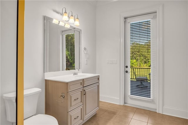 bathroom with toilet, tile patterned flooring, a wealth of natural light, and vanity