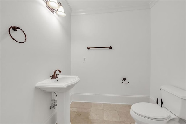 bathroom with ornamental molding, toilet, and baseboards