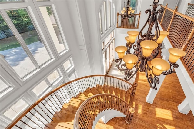 staircase with a chandelier and wood finished floors