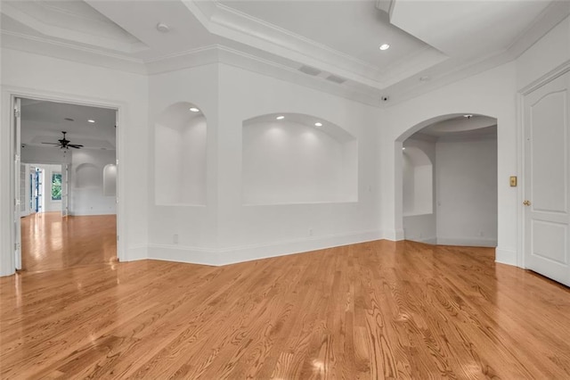 unfurnished room featuring a tray ceiling, crown molding, light wood finished floors, and recessed lighting