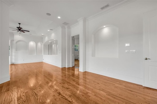 empty room with visible vents, light wood-style flooring, ceiling fan, crown molding, and recessed lighting