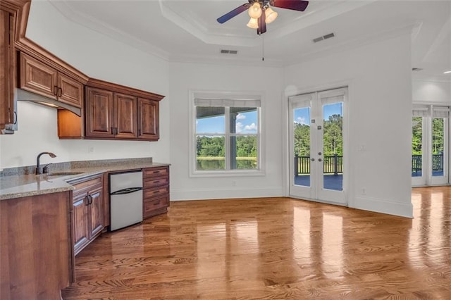 kitchen featuring a tray ceiling, french doors, a sink, and visible vents