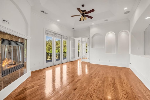 unfurnished living room featuring a fireplace, visible vents, baseboards, light wood-style floors, and crown molding