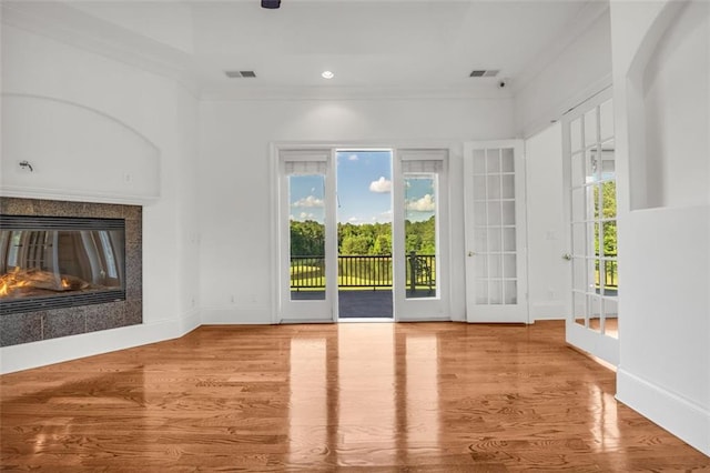 unfurnished living room with baseboards, a multi sided fireplace, a wealth of natural light, and light wood-style floors