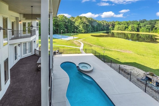 view of swimming pool with a water view, fence private yard, a patio, and french doors