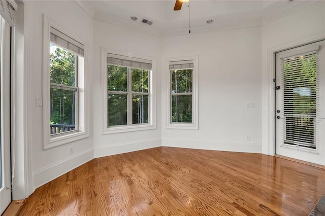 interior space with light wood-style floors, visible vents, ornamental molding, and baseboards