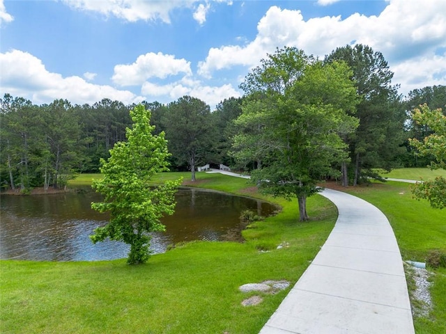 view of property's community with a water view and a yard