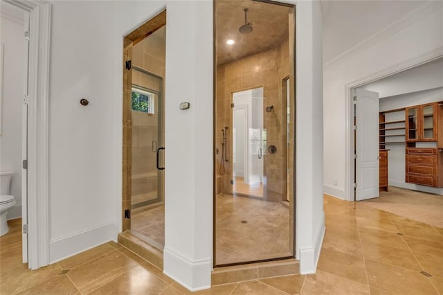 bathroom featuring baseboards, a shower stall, toilet, and tile patterned floors