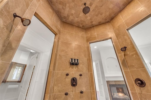 full bathroom featuring tiled shower and a tiled fireplace