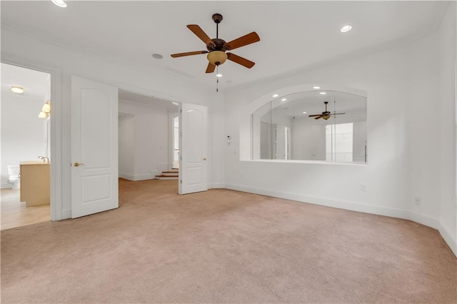 spare room with arched walkways, recessed lighting, light colored carpet, ceiling fan, and baseboards