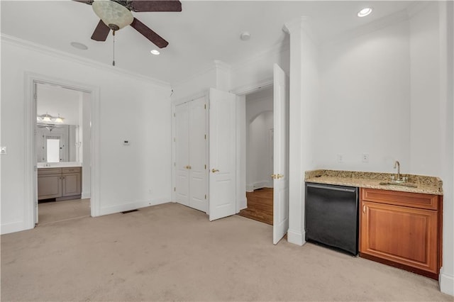 bar with arched walkways, light colored carpet, a sink, ornamental molding, and fridge