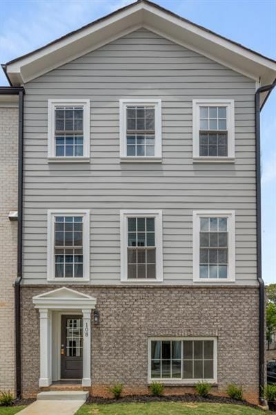 view of front of home featuring brick siding and a front lawn