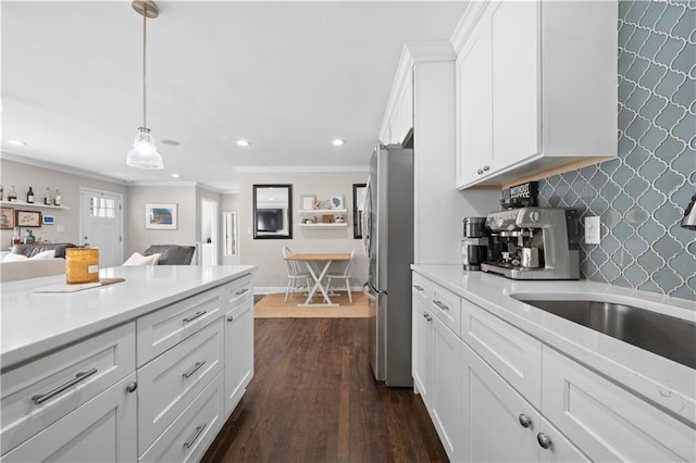 kitchen featuring stainless steel fridge, hanging light fixtures, ornamental molding, white cabinets, and dark hardwood / wood-style flooring