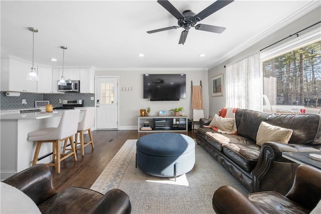 living room with ornamental molding, ceiling fan, and dark hardwood / wood-style flooring