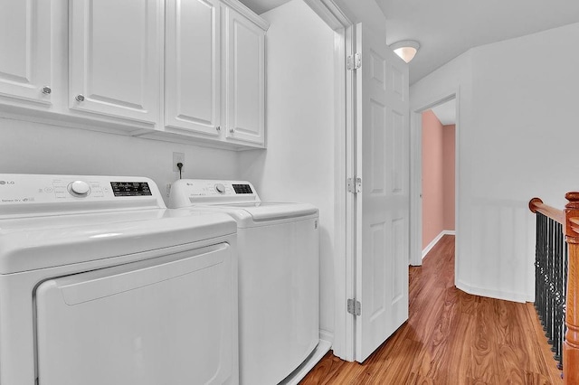 laundry area with wood finished floors, cabinet space, independent washer and dryer, and baseboards