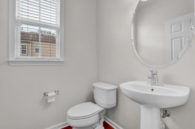 bathroom featuring baseboards and toilet