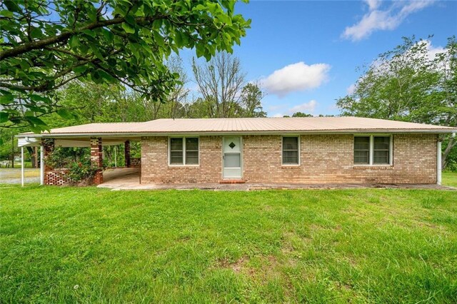 view of front of property with a carport, a front lawn, and brick siding