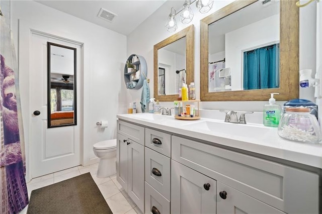 bathroom featuring toilet, vanity, and tile patterned floors