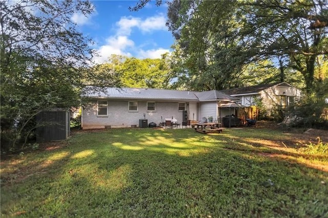 back of property with cooling unit and a lawn