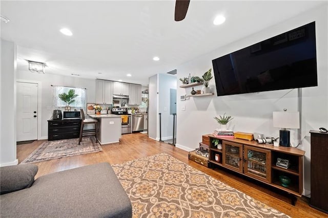 living room with ceiling fan and light hardwood / wood-style floors