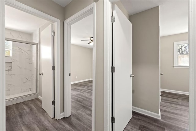 corridor with baseboards and wood finished floors