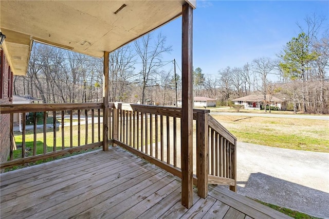 wooden deck featuring a lawn