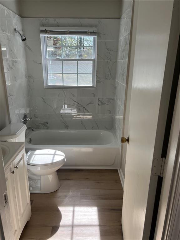 bathroom featuring toilet, shower / bathing tub combination, wood finished floors, and vanity